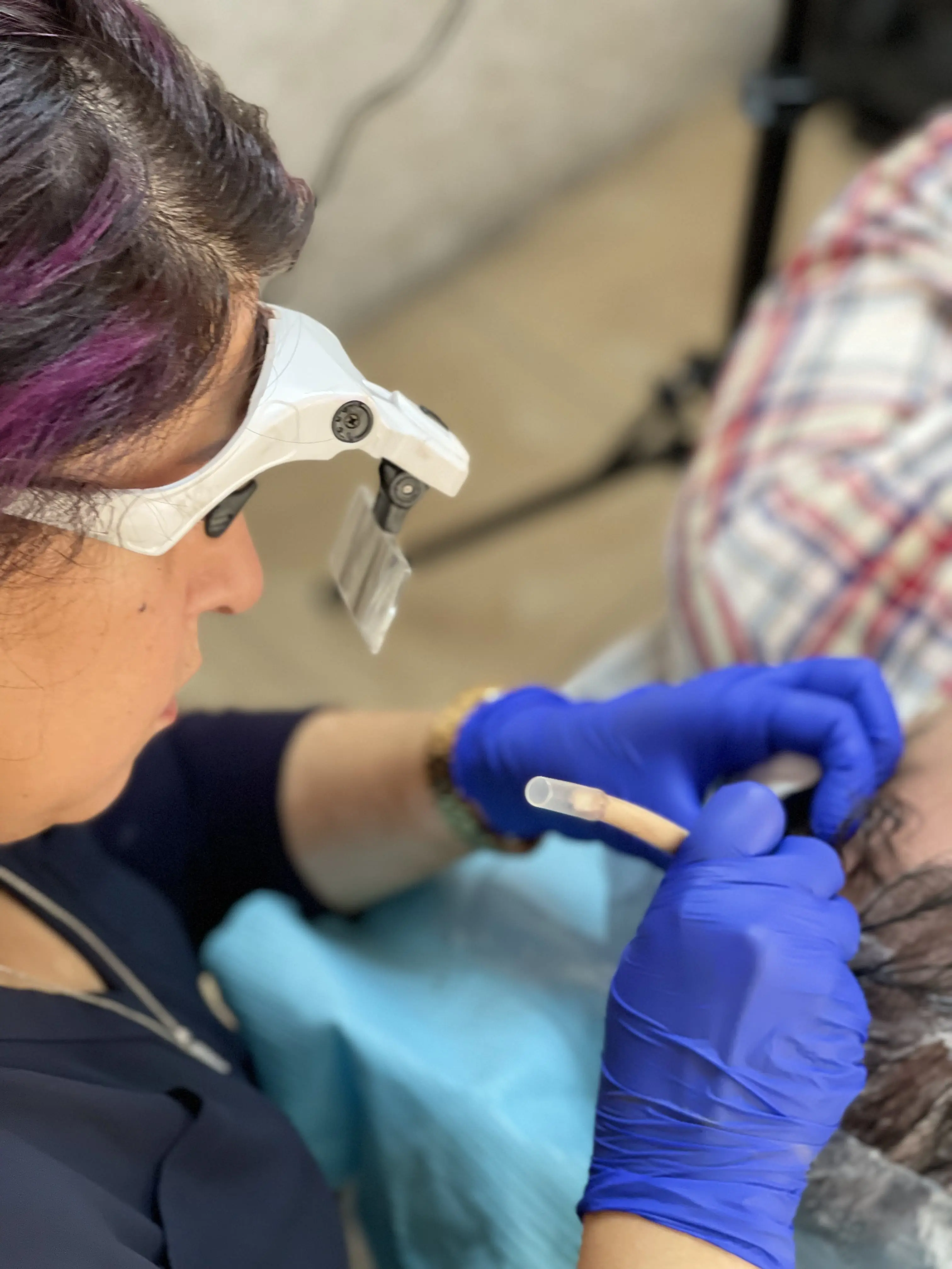 Nadia wearing magnifying glasses during a scalp micropigmentation procedure
